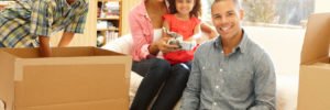 Mixed race family of four moving into their new place unpacking all of their belongings from the long-distance move